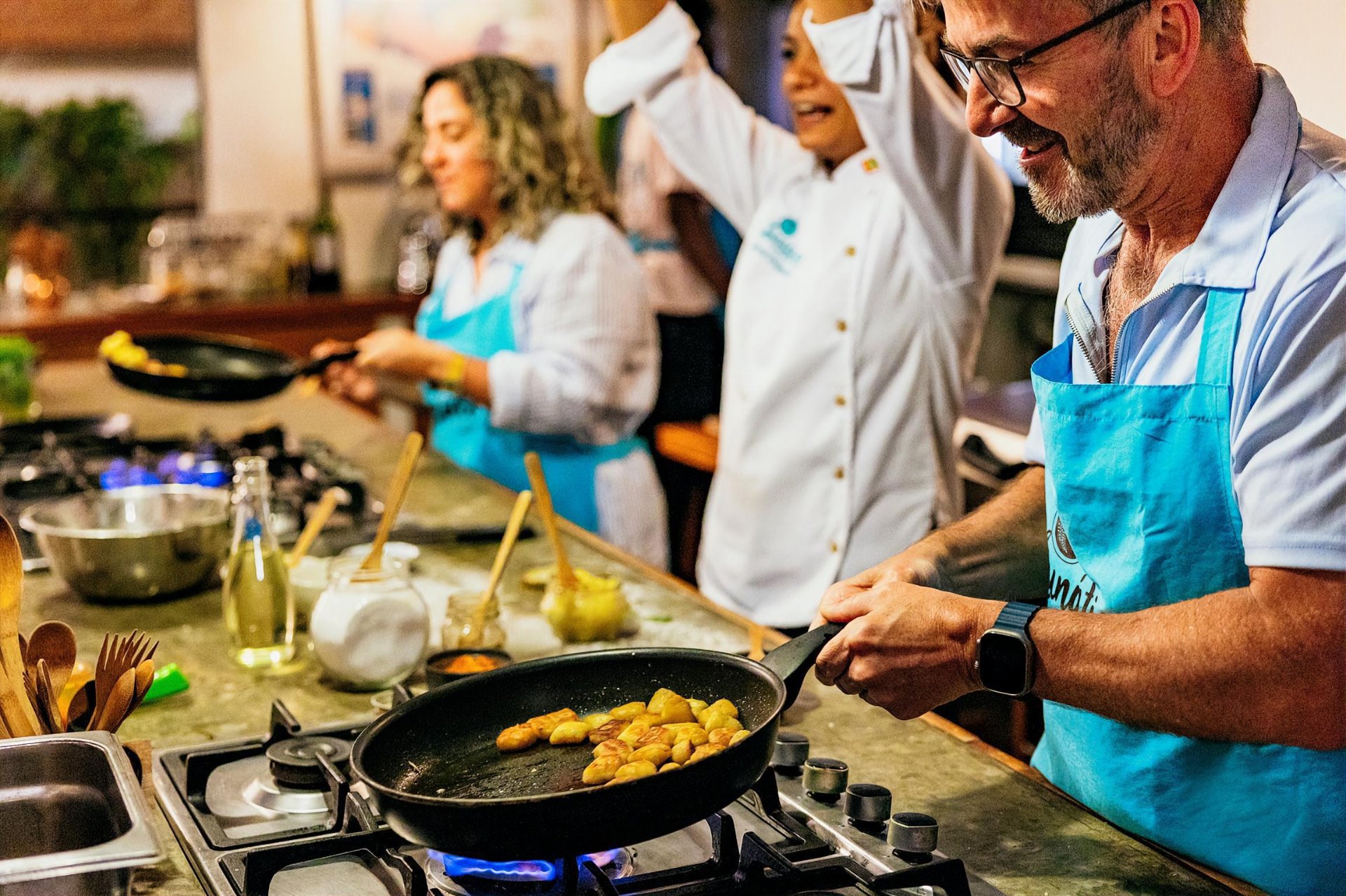 Guest cooking plantains during a Colombian cooking class