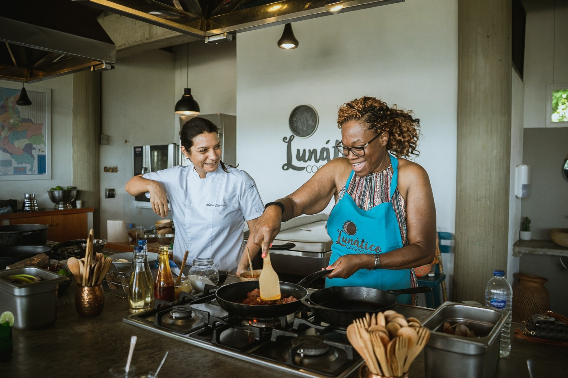 Lunático chef guiding a guest cooking at the stove during a hands-on Colombian cooking class in Cartagena