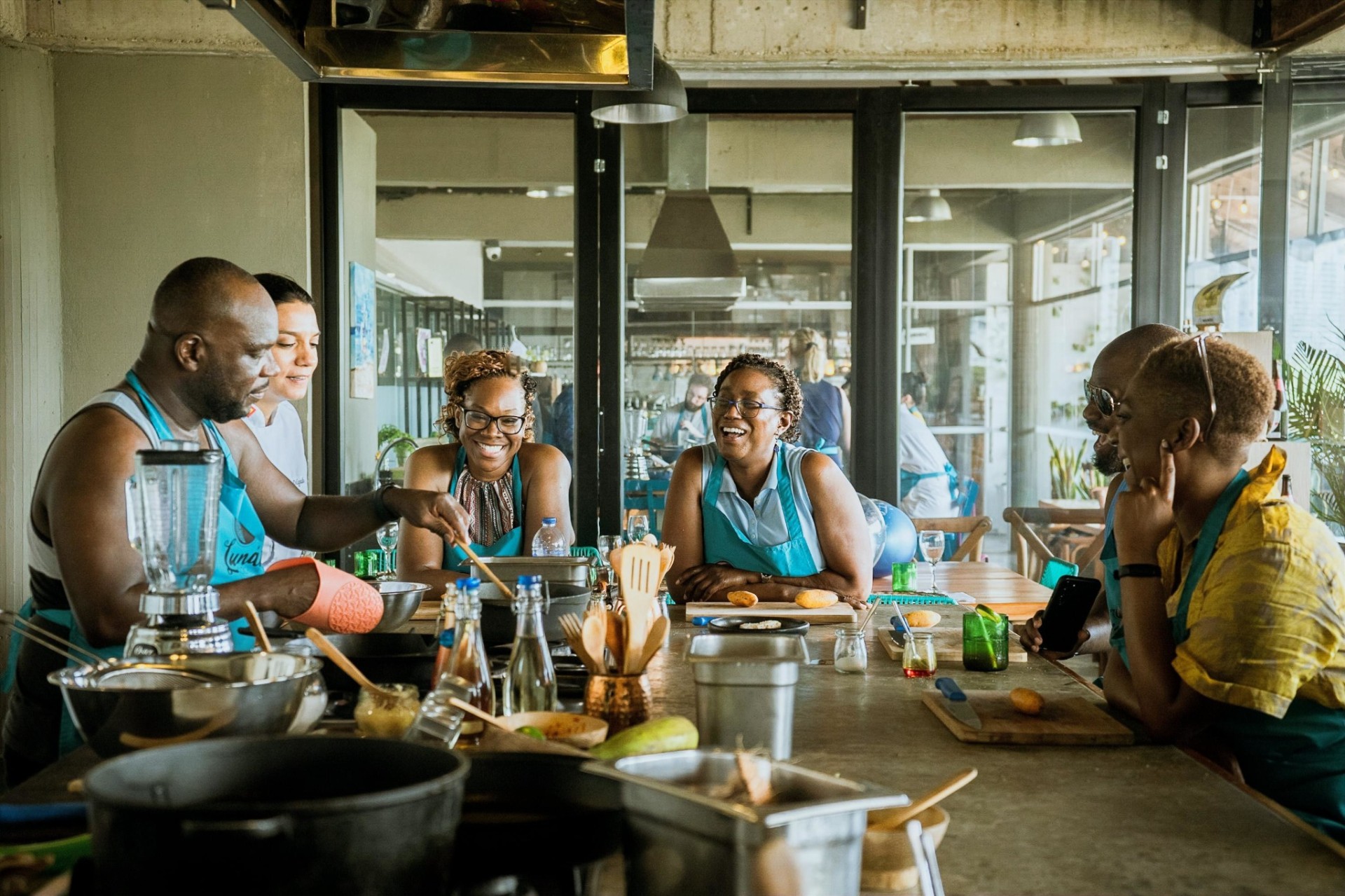 Family and friends laughing together during a private Colombian cooking experience at Lunático